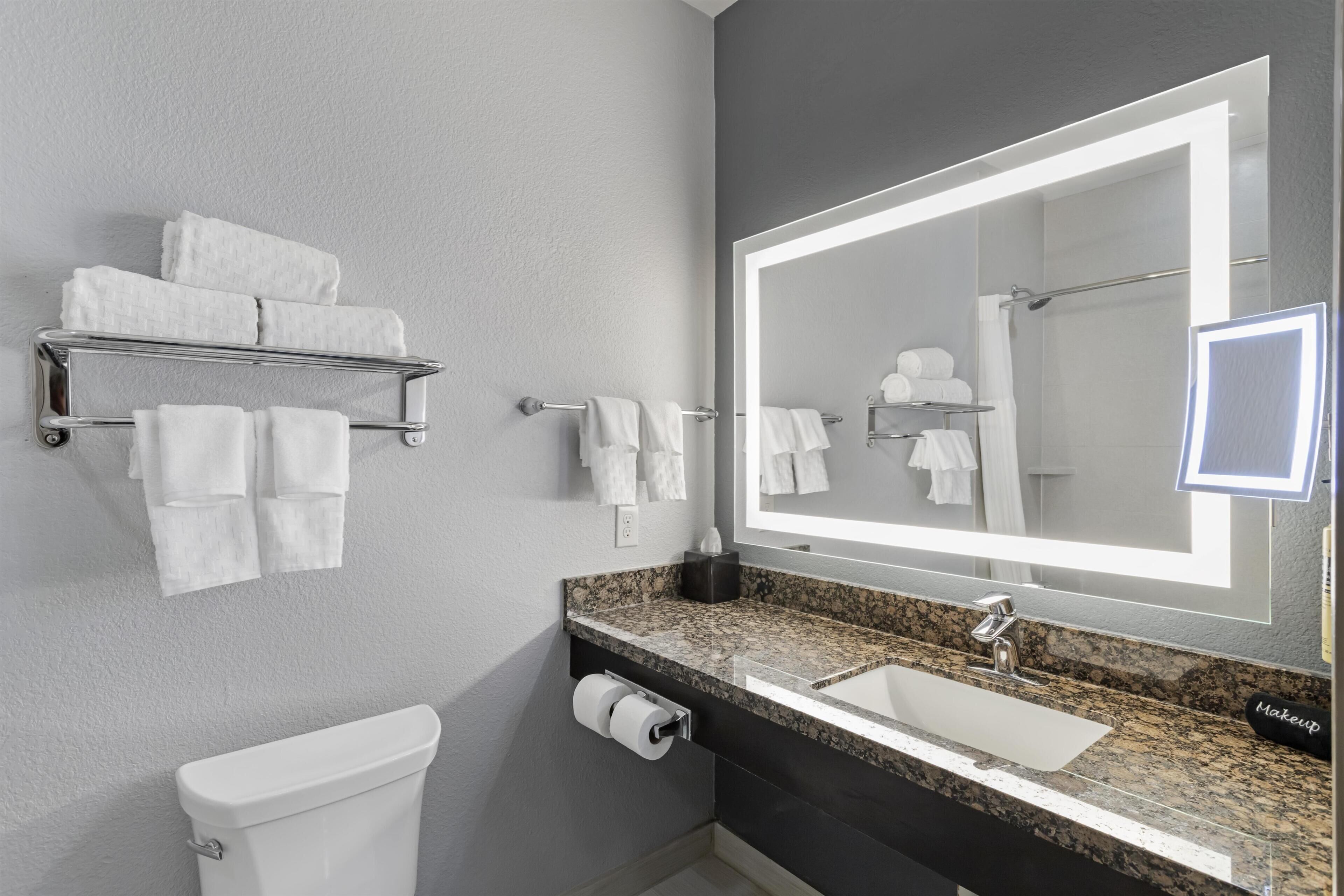 A modern bathroom with a toilet, sink, and towel rack.