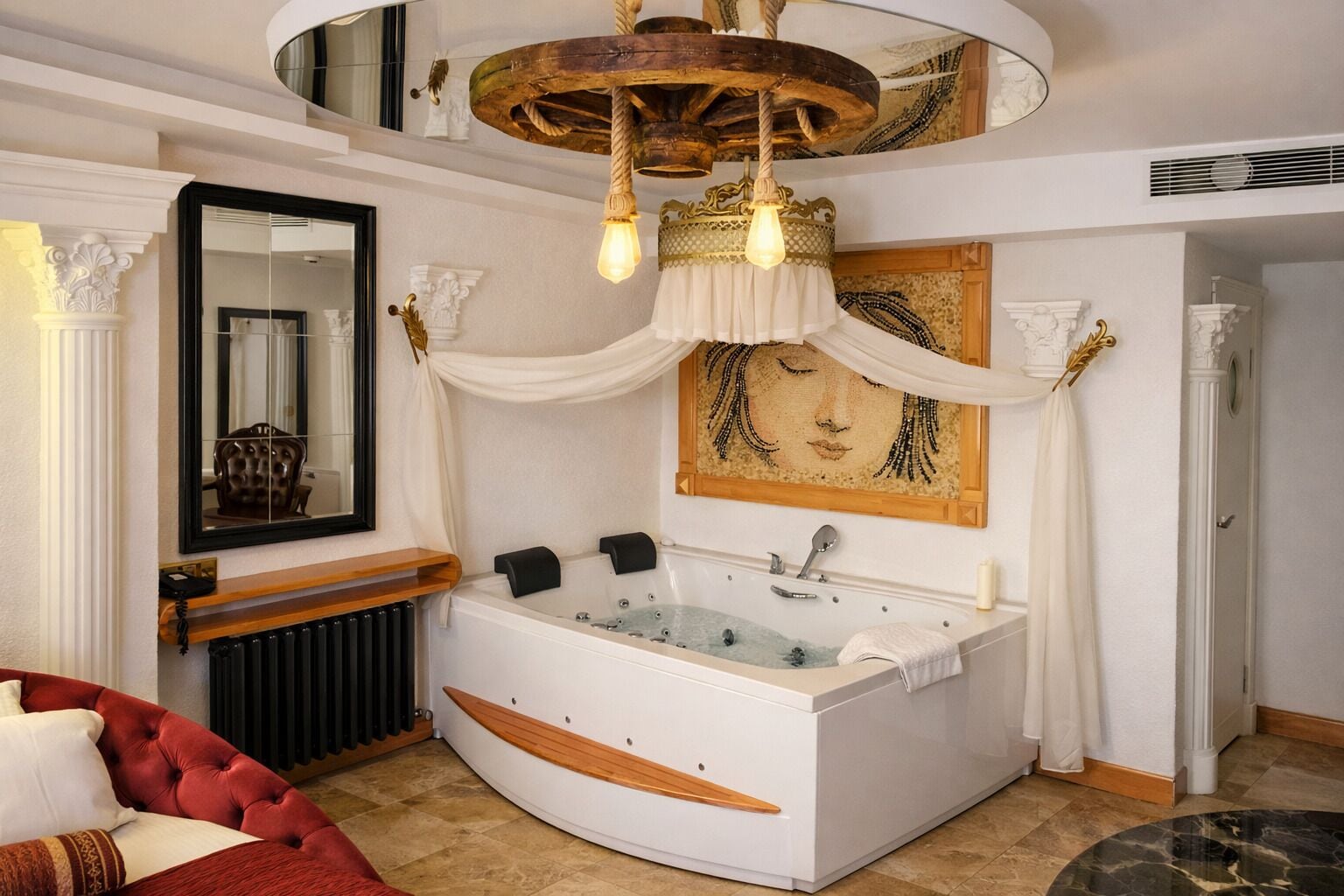A luxurious bathroom with a large bathtub, a mirror, and a decorative ceiling light.