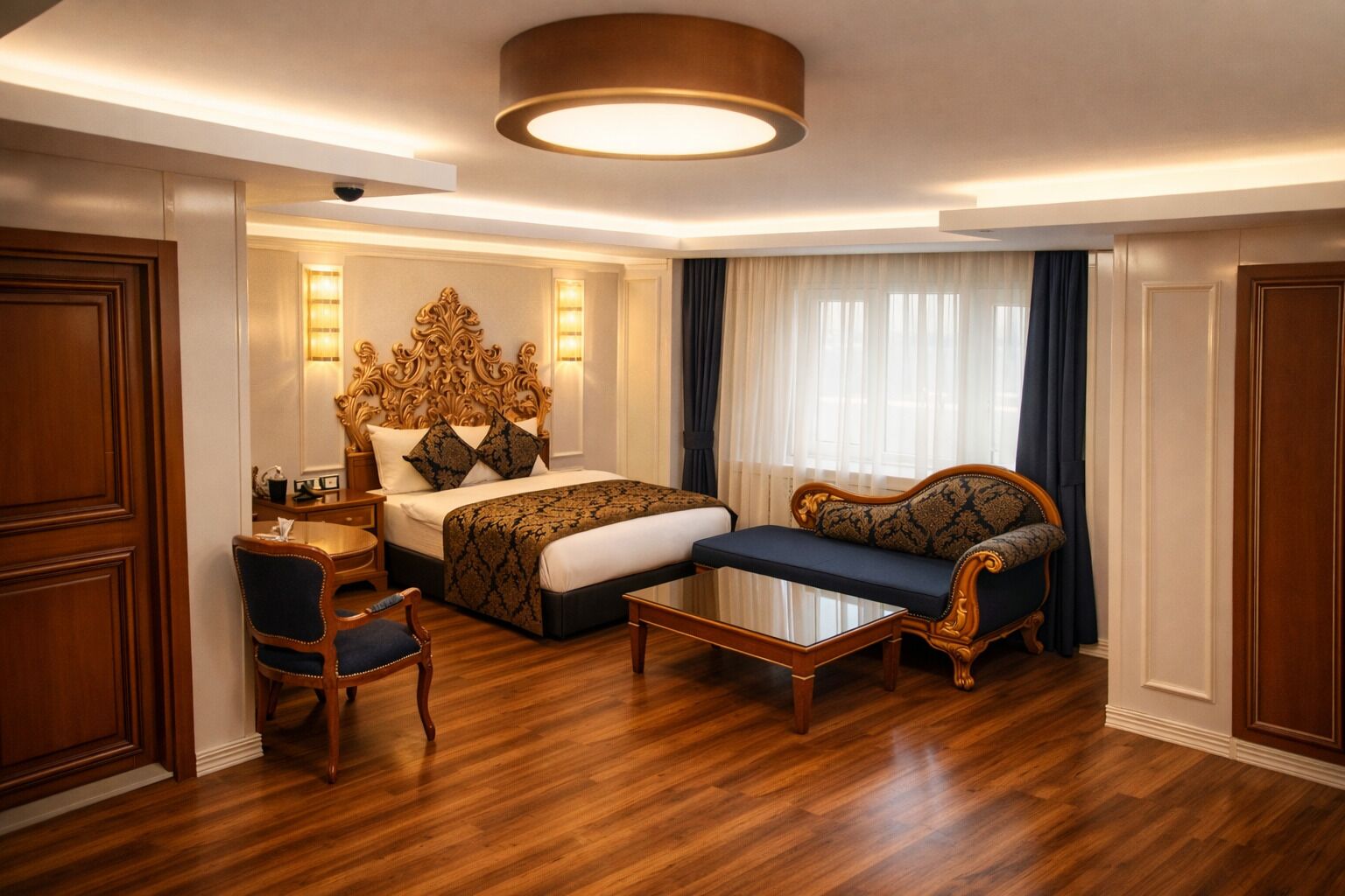 Una habitación de hotel con una cama grande, un sofá, una silla y una mesita.
