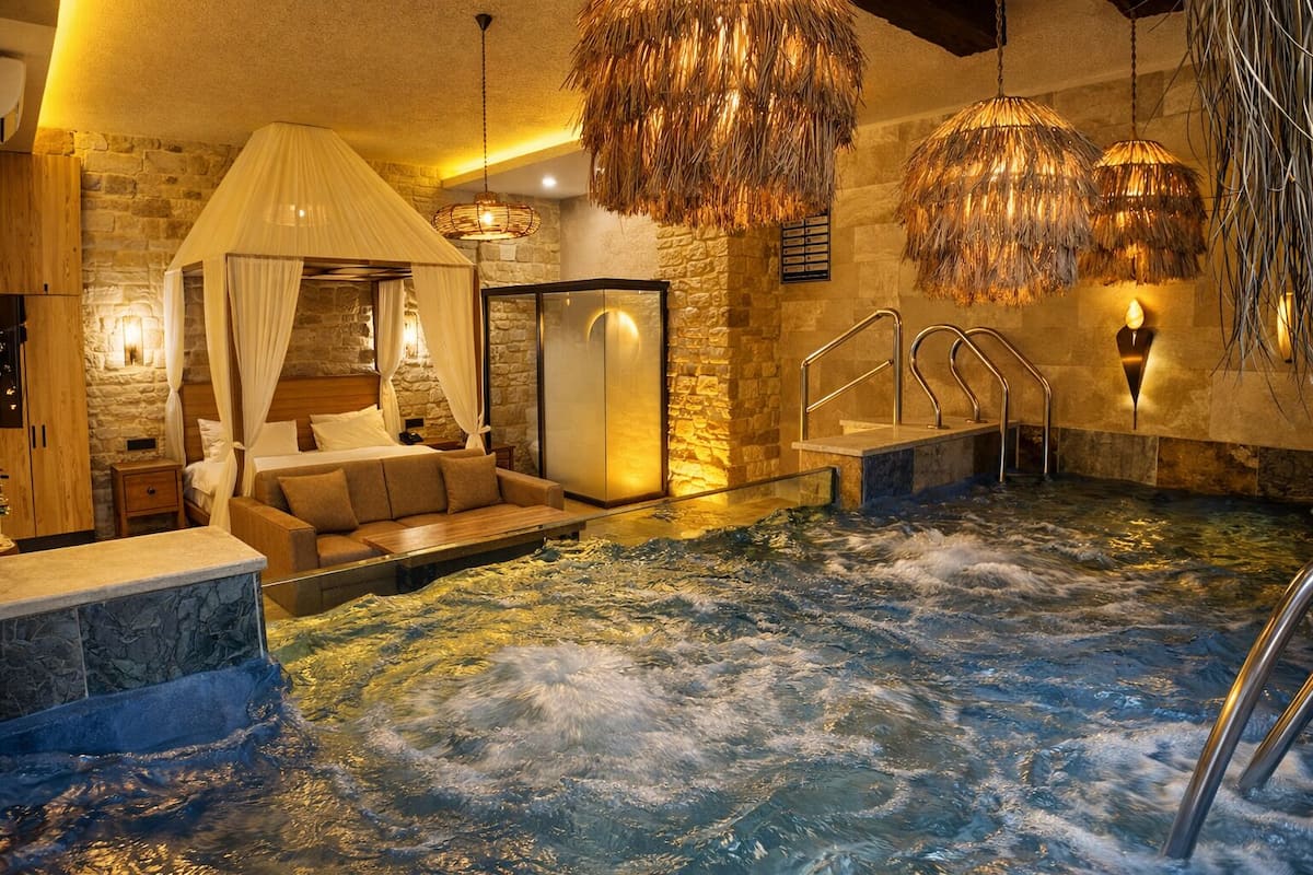 A spa area with a hot tub, a sofa, and a canopy bed.
