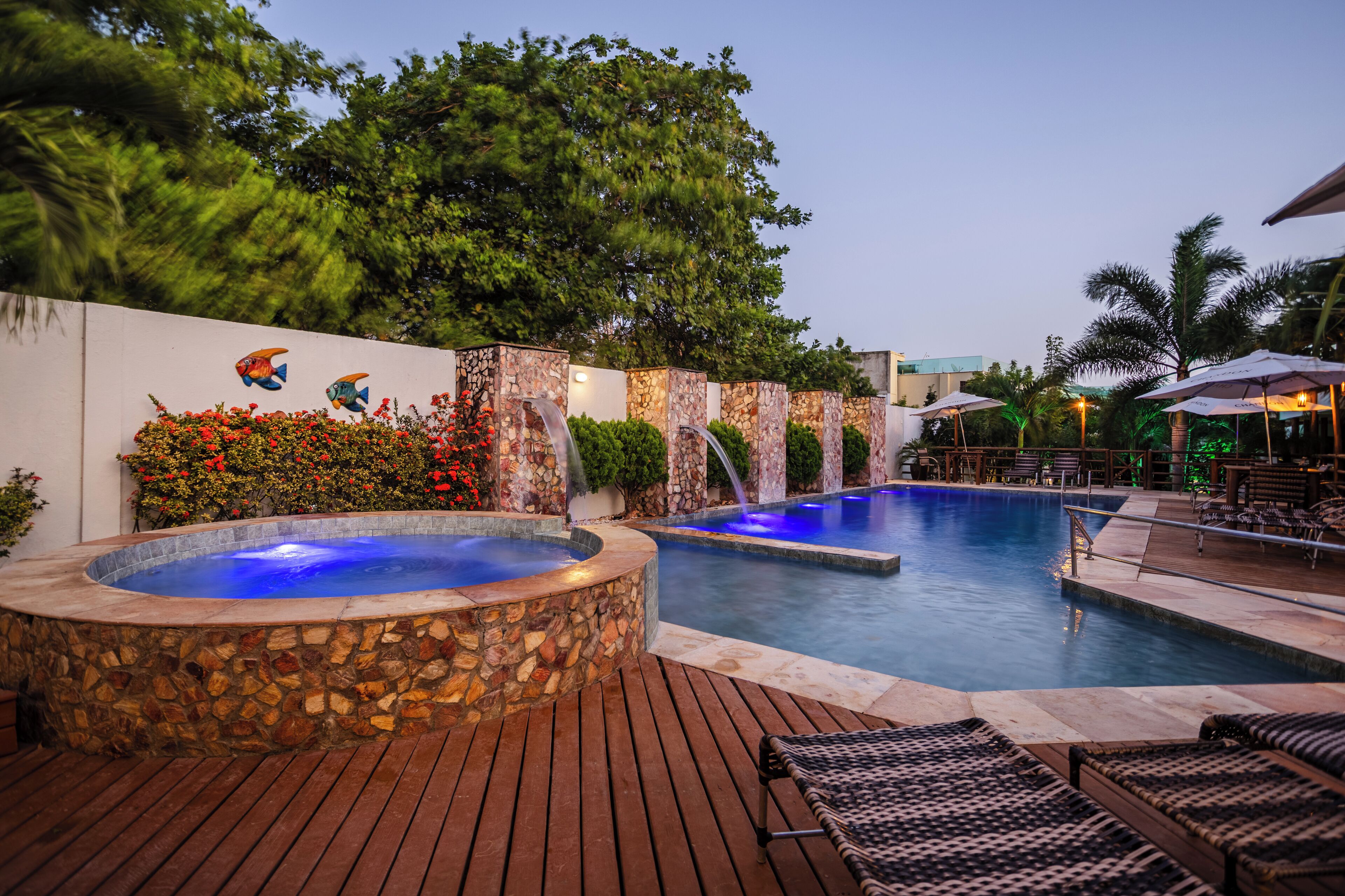 Una piscina con hidromasaje, rodeada de muros de piedra y cubierta de madera.