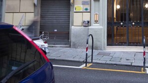 Un edificio con una puerta tapiada, una amplia entrada en arco y una pequeña señal sobre la puerta.