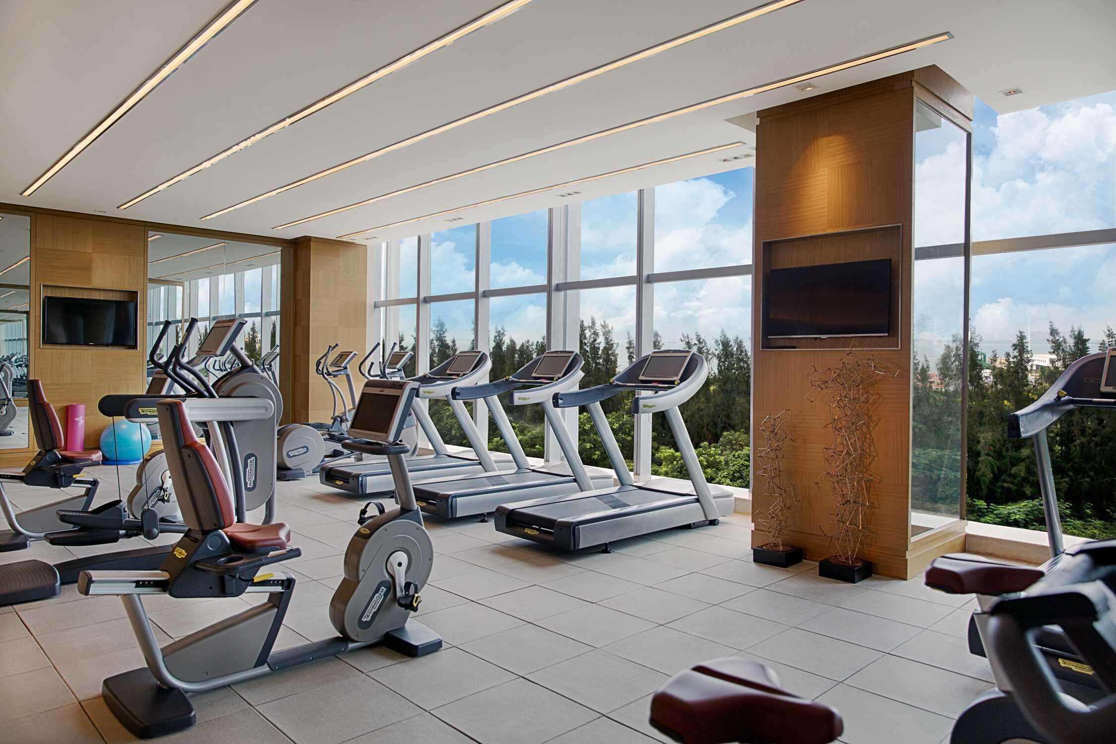Ein modernes Fitnessstudio mit Laufbändern, Ergometer und Krafttrainingsgeräten.