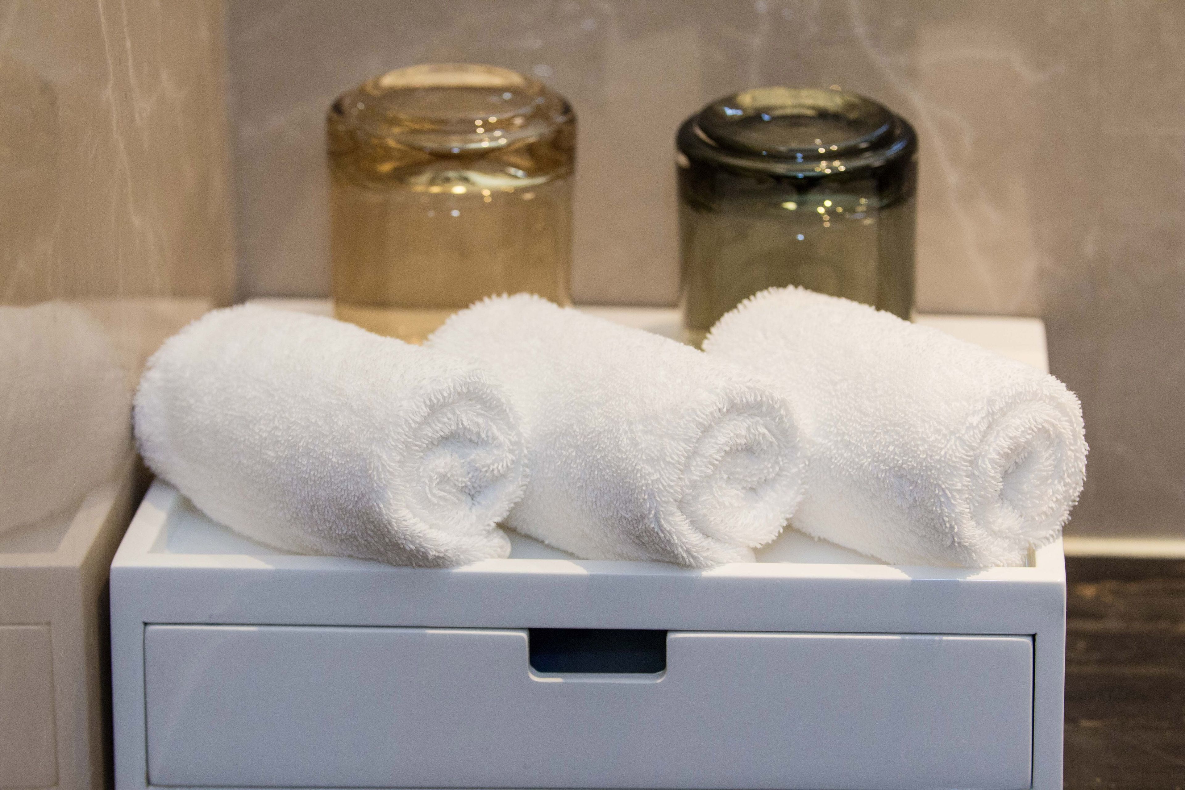 Une salle de bain équipée d’un distributeur de serviettes blanches contenant deux serviettes enroulées.