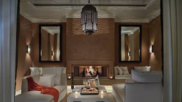 A modern living room with a fireplace, two sofas, a coffee table, and decorative lighting.
