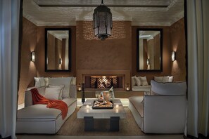 A modern living room with a fireplace, two sofas, a coffee table, and decorative lighting. - Mandarin Oriental, Marrakech (Marrakech)