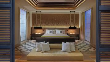 Quarto moderno com cama grande, mesas de cabeceira e um painel decorativo na parede.