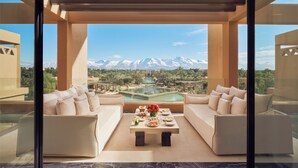 A modern outdoor seating area with a pool, a mountain view, and a clear sky. - Mandarin Oriental, Marrakech (Marrakech)