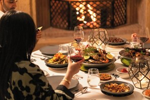 A dining table set with various dishes, glasses of wine, and a decorative lantern. - Mandarin Oriental, Marrakech (Marrakech)