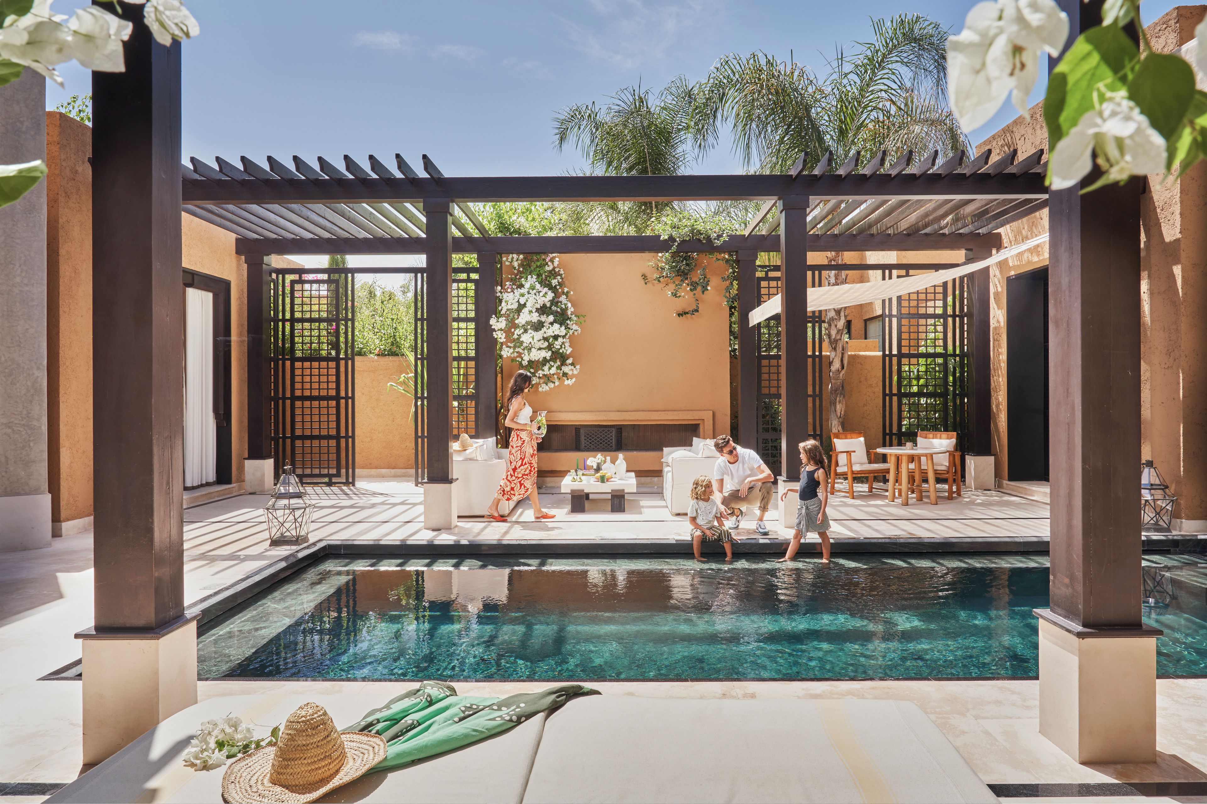A pool area with a pergola, seating, and a clear view of the pool.