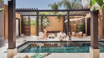 A pool area with a pergola, seating, and a clear view of the pool.