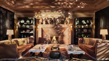 A cozy living room with leather sofas, a coffee table, and a fireplace.