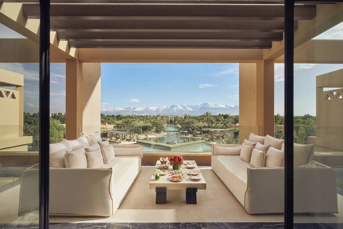 A modern outdoor seating area with a pool and mountain view.