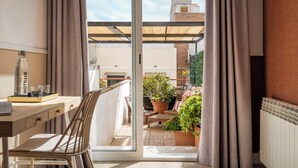 A balcony with a wooden table, chairs, and a bottle of BYPILLOW water. - BYPILLOW House (Barcelona)