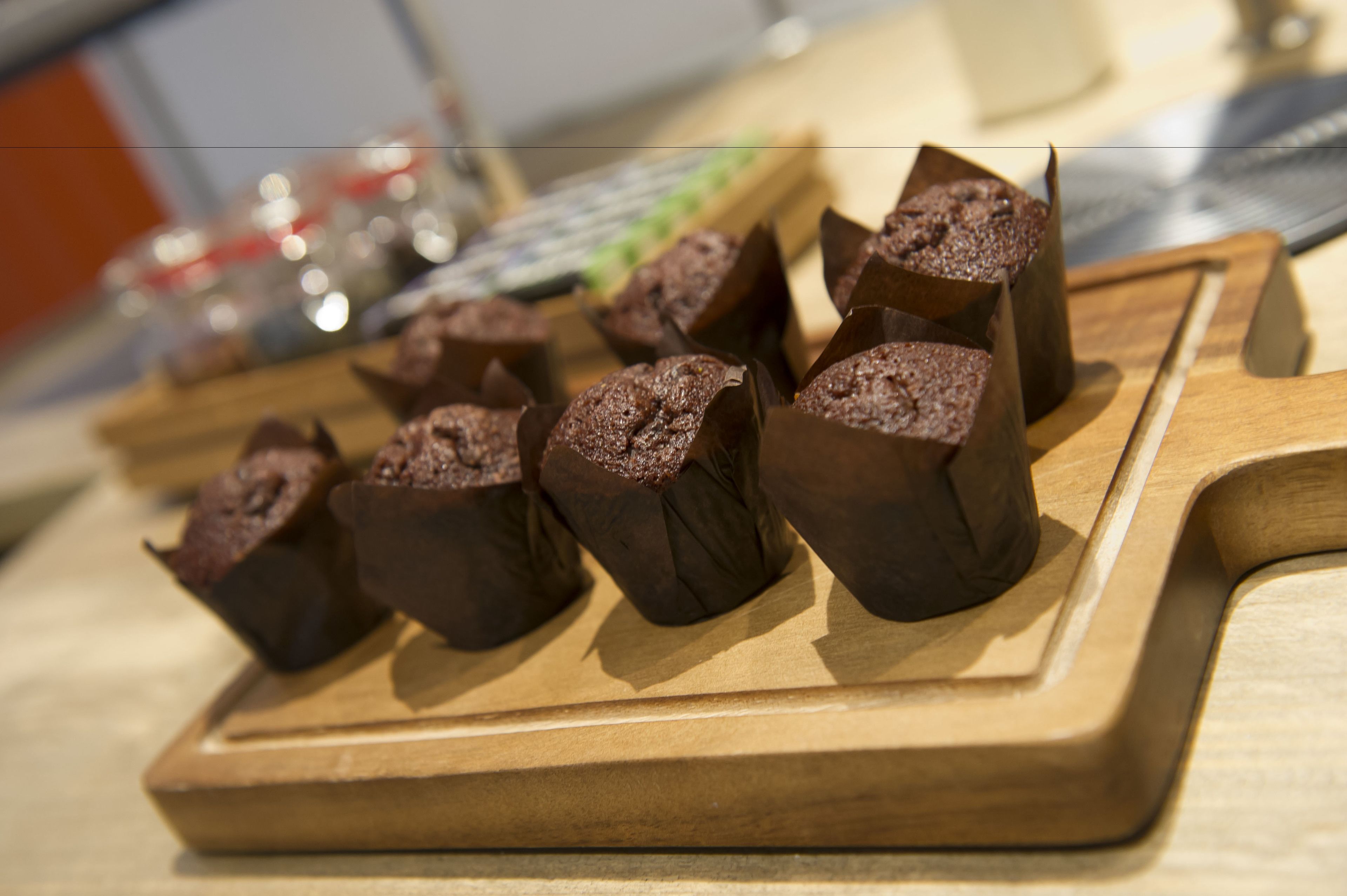 A wooden board with several chocolate-covered items, possibly pastries, on a table.