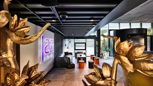 Un interior moderno con una mesa de recepción, una zona de estar y un cartel que dice 'Jazz in the city'.