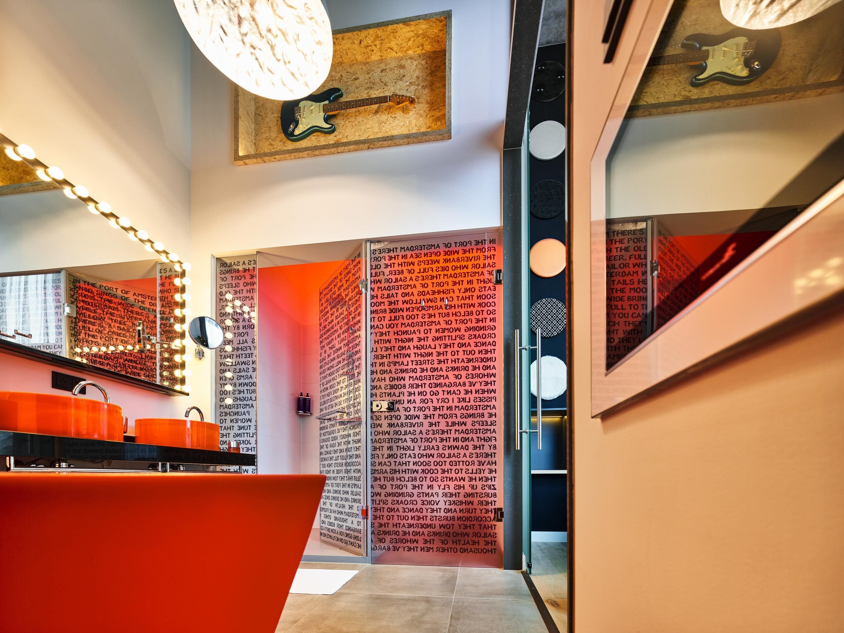A modern bathroom with a vanity, mirror, and lights.