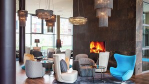 A modern lounge area with a fireplace, comfortable seating, and large windows. - Motel One Wien-Hauptbahnhof (Vienna)