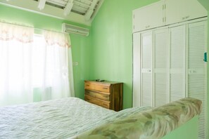 A bedroom with a bed, a dresser, and a wardrobe. - Gemini Villa (Montego Bay)