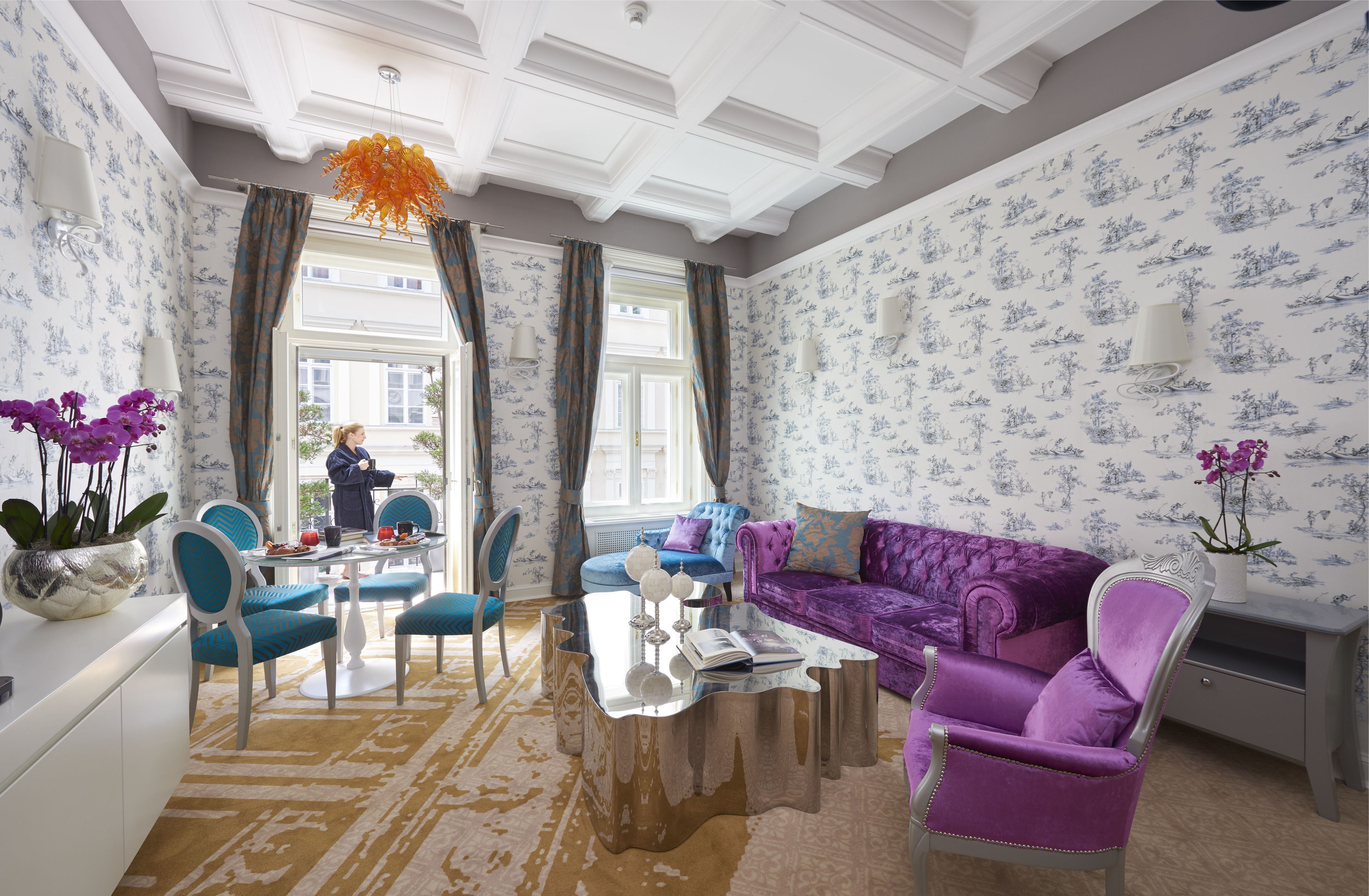 A spacious living room with a large sofa, a coffee table, and a dining area with chairs and a table.