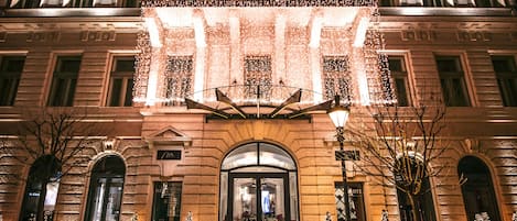 A grand building with a symmetrical facade, large arched entrance, and multiple windows.