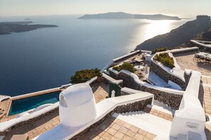 A coastal hotel with a pool, stone walls, and a view of the sea. - The Vasilicos (Santorini)