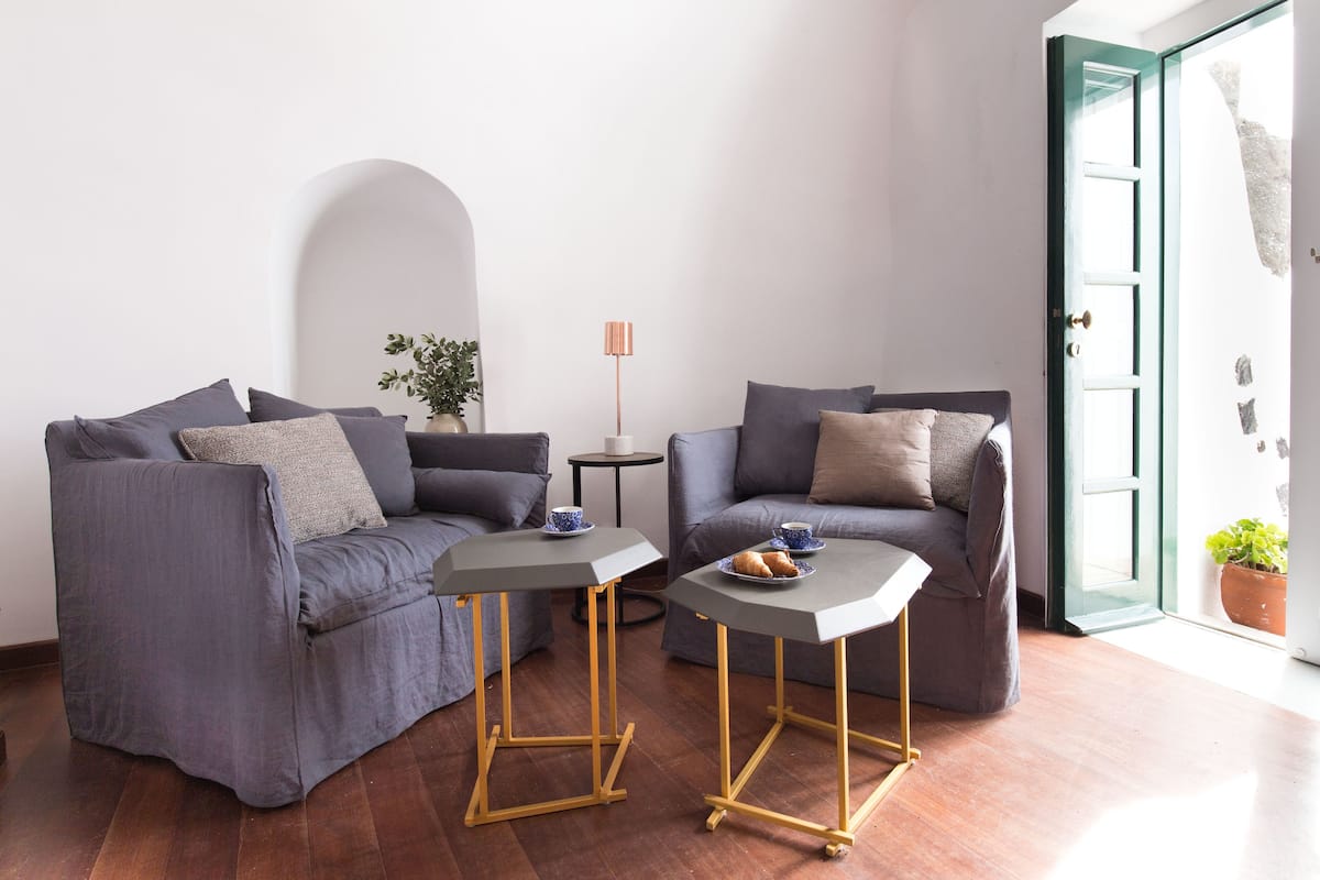 A modern living room with two sofas, a small table, and a floor lamp.