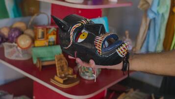 A hand holding a black mask with colorful patterns.