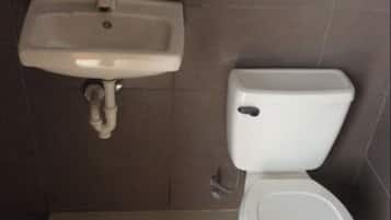 Ein Badezimmer mit einem weißen Waschbecken und einer Toilette.