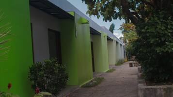 A row of green buildings with a narrow pathway between them.