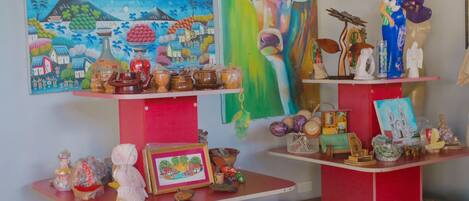 Una habitación con estanterías rojas que exhiben diversos objetos decorativos, como cerámica, figuritas y pinturas.