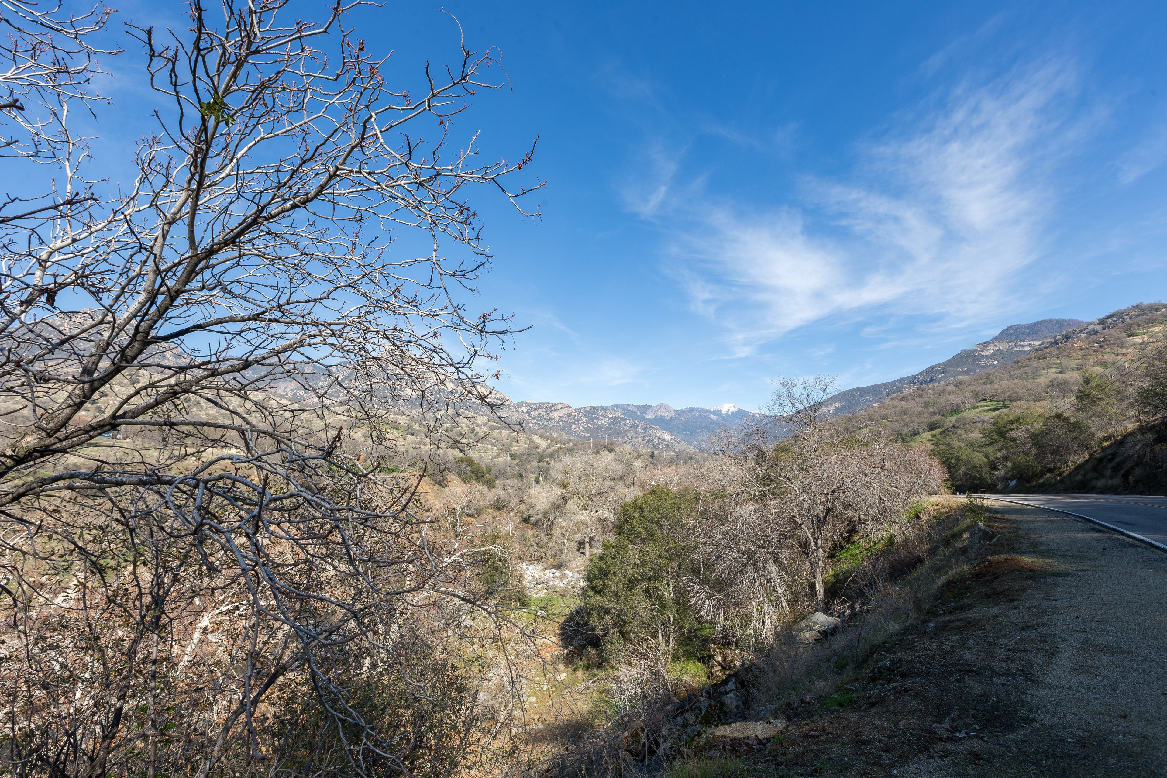 A rural road with a mountainous backdrop.