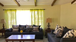 A living room with two sofas, a coffee table, and two lamps. - The River Inn (Three Rivers)