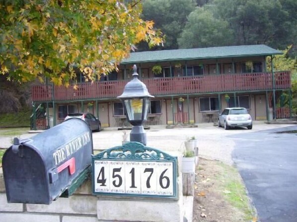 Un edificio con techo verde, un buzón con la leyenda 'The River Inn' y el número de casa '45176'.