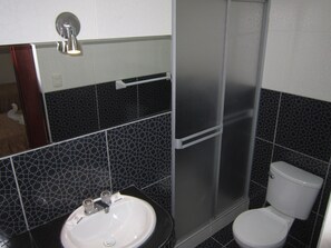 A bathroom with a white sink, a toilet, and a shower enclosure. - Plaza Trujillo Hotel (Trujillo)
