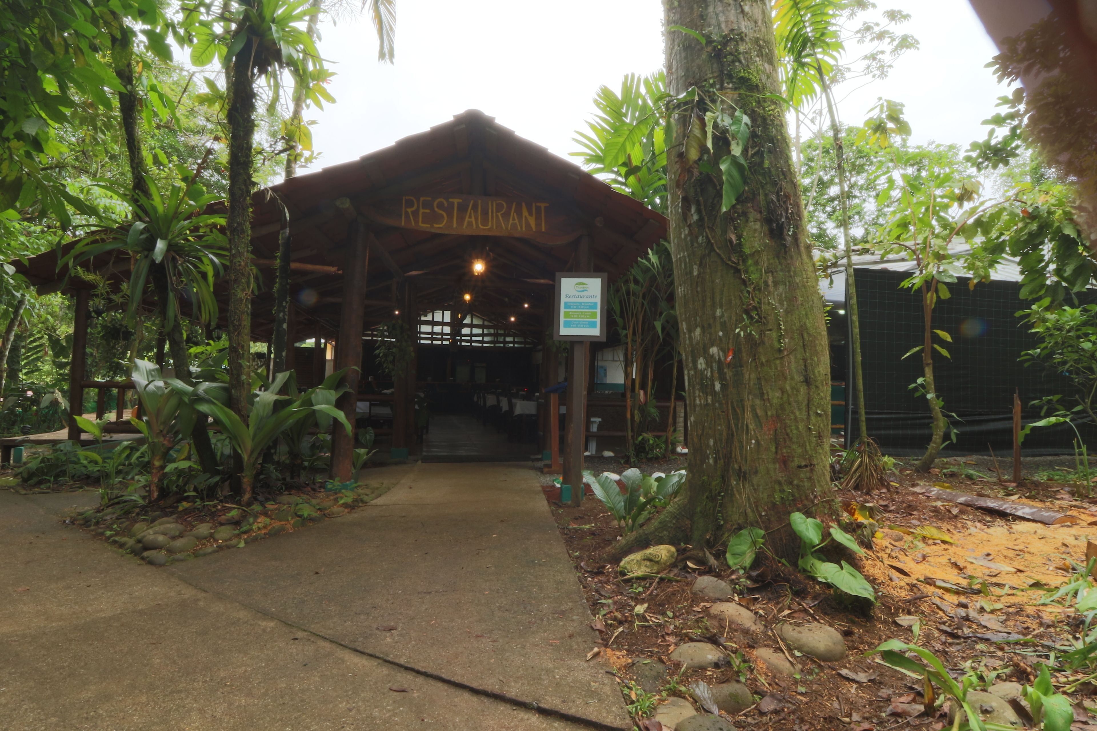 Un restaurant avec un toit en bois et une enseigne sur laquelle on peut lire « RESTAURANT ».
