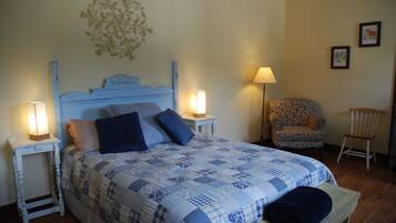 Une chambre à coucher comprenant un lit, deux tables de chevet avec des lampes, une chaise et un élément décoratif mural.