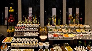Een buffet met diverse gerechtjes, waaronder salades, Indiase zoetigheden, desserts en verschillende soorten gerechten.