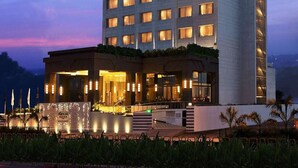 Een meerlaags hotel met een opvallend 'FORTUNE' bord, met een moderne gevel en verlichte ramen.