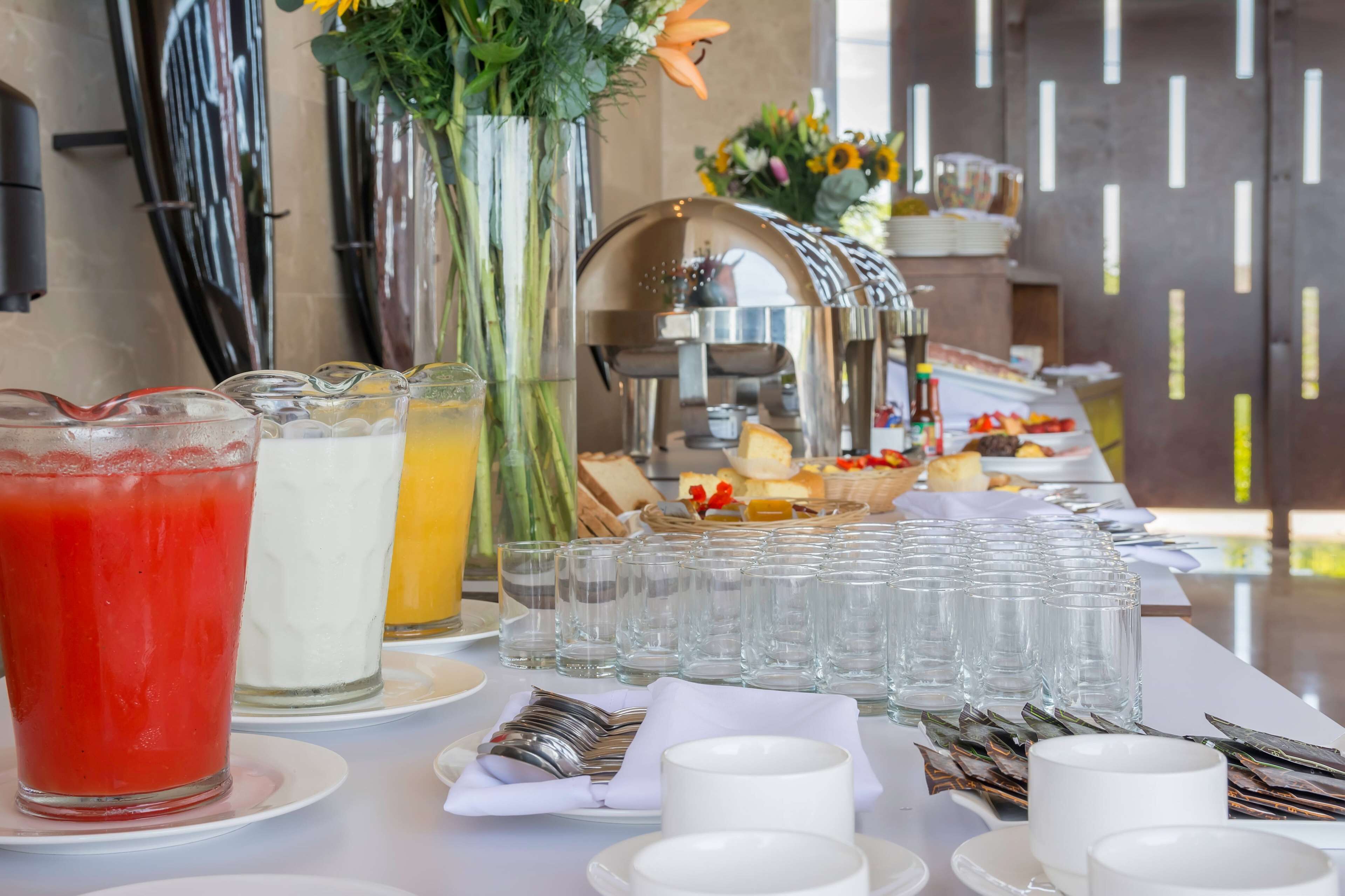 Un buffet de petit-déjeuner proposant une variété d’aliments, une machine à café et un assortiment de boissons.