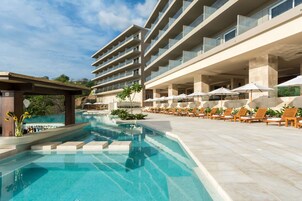 Una piscina al aire libre, sillones reclinables de piscina