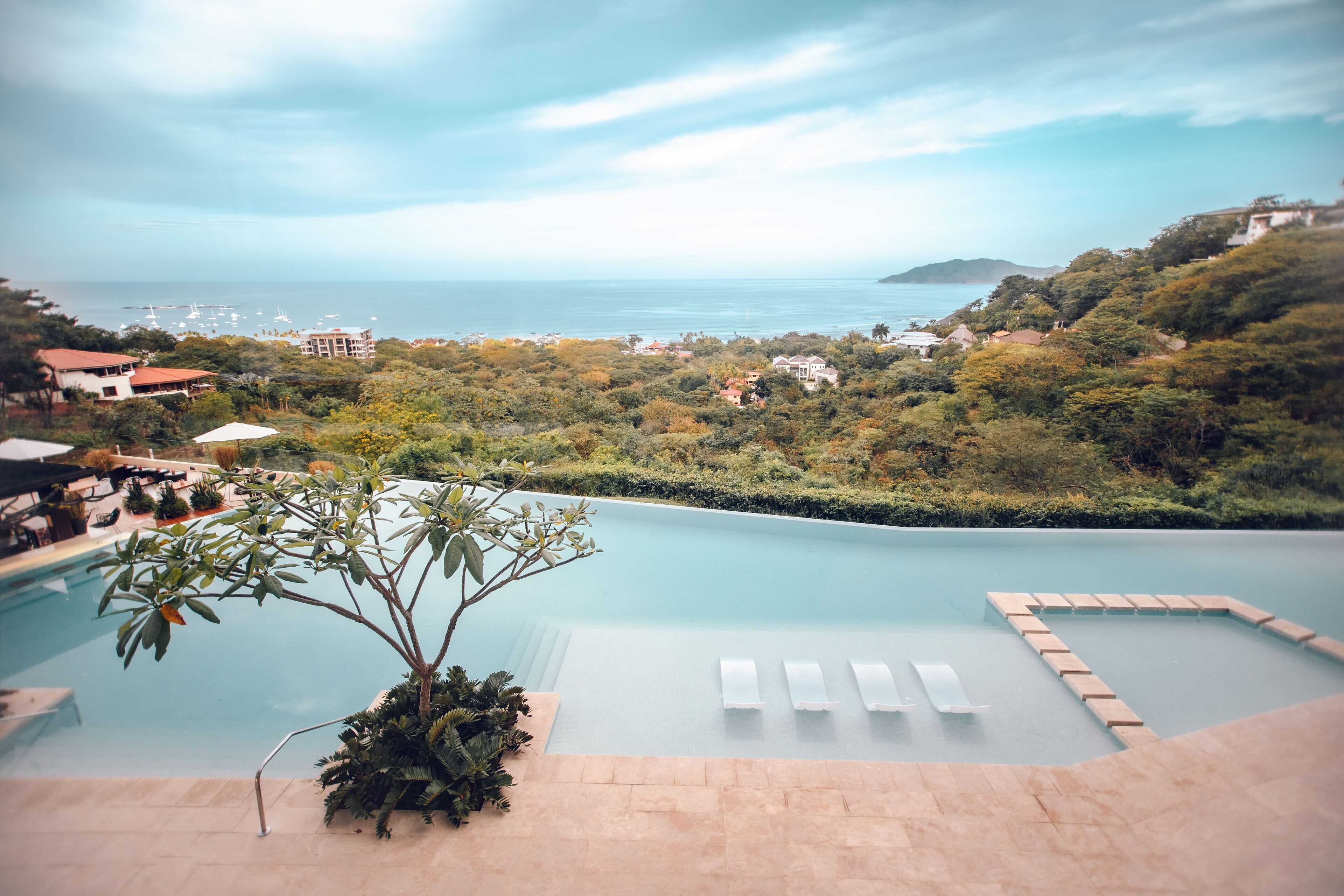 Una piscina con lettini e vista sull'oceano.