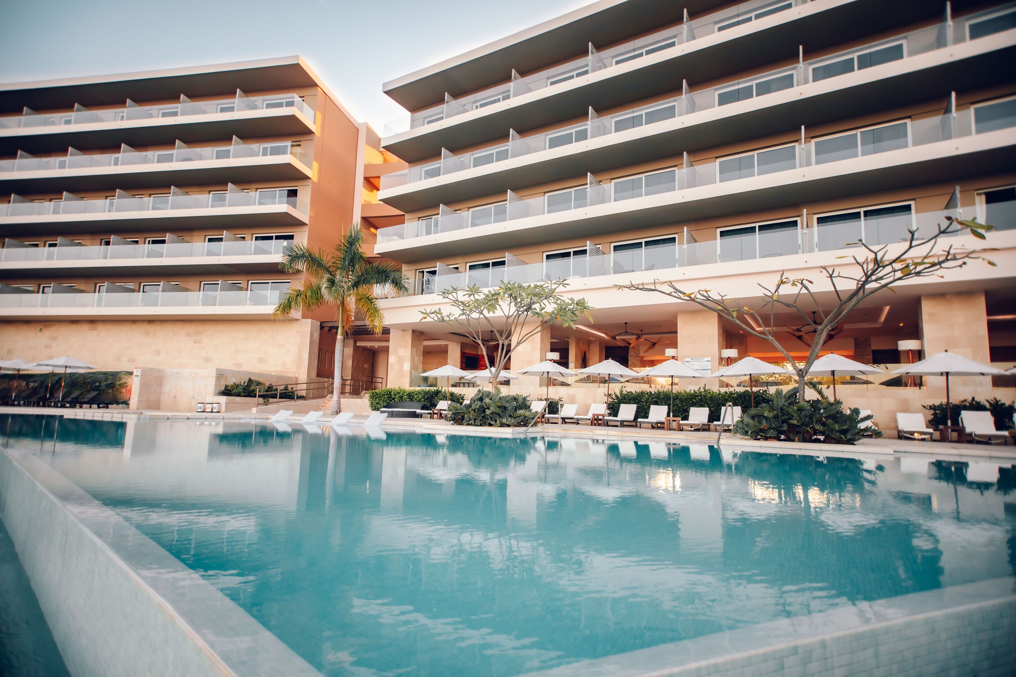 Un hôtel doté d’une piscine, de nombreux balcons et d’espaces extérieurs aménagés pour se détendre.