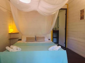 Una habitación con una cama, almohadas y toallas enrolladas.