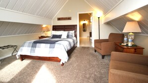 A bedroom with a wooden bed, a nightstand, a chair, a lamp, and a mirror. - Sweetgrass Inn B&B (Rapid City)