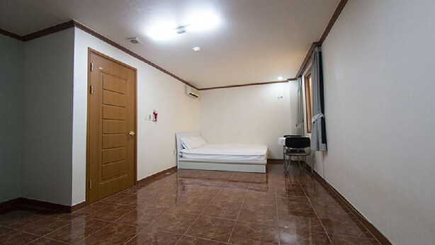Una habitación de hotel con cama, puerta y ventana.