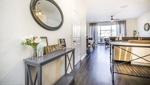 A modern kitchen with a dark wood floor, a large round mirror, and a dining area with a table and chairs. - Windsor Hill Resort (Kissimmee)
