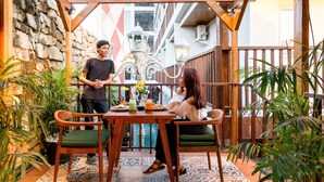 A wooden pergola with a table and chairs, surrounded by potted plants. - Hadi Poetra Hotel (Kuta)