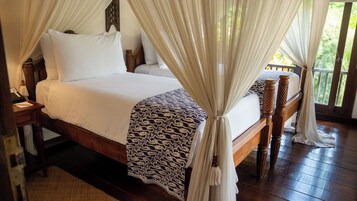 A double bed with a canopy, wooden headboard, and a patterned throw.