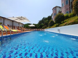 季节性开放的室外游泳池，13:00 至 20:00 开放，池畔遮阳伞，日光浴躺椅